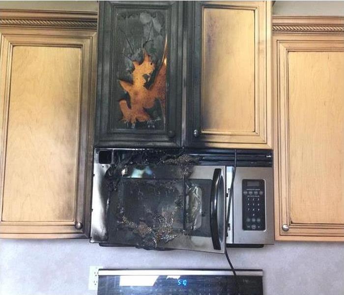 Charred Kitchen wood cabinets and stainless steel microwave